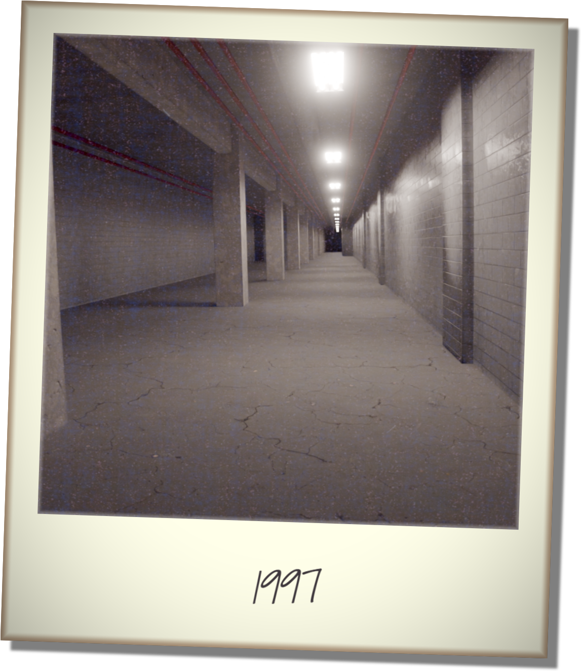 A polaroid of an empty concrete warehouse-like space, with exposed pipes on the ceiling. Text written on the bottom has the year 1997.