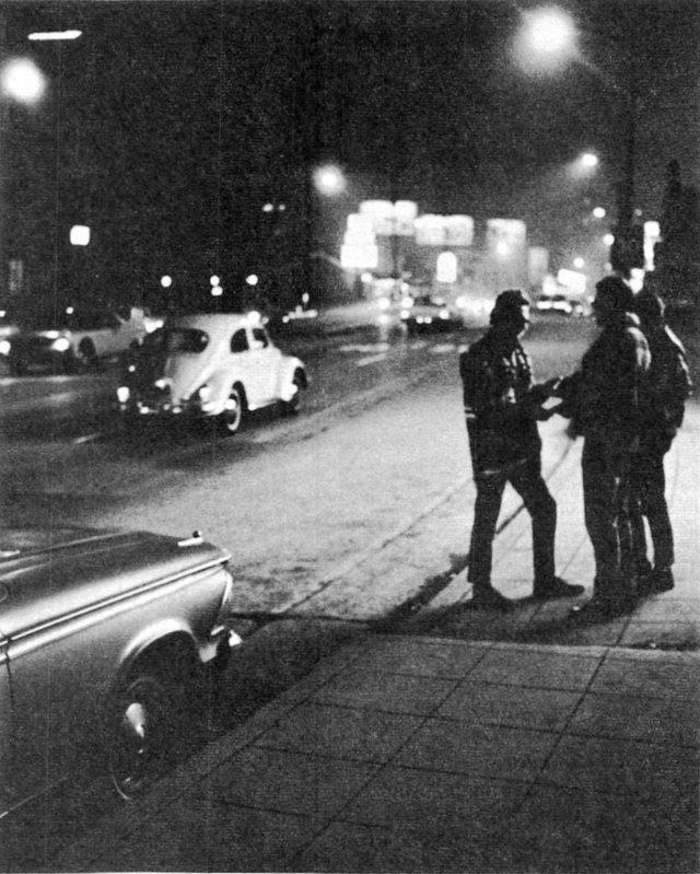 Black-and-white image of two figures engaged in trade.