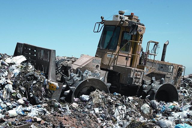 Landfill compactor on a pile of metal debris.