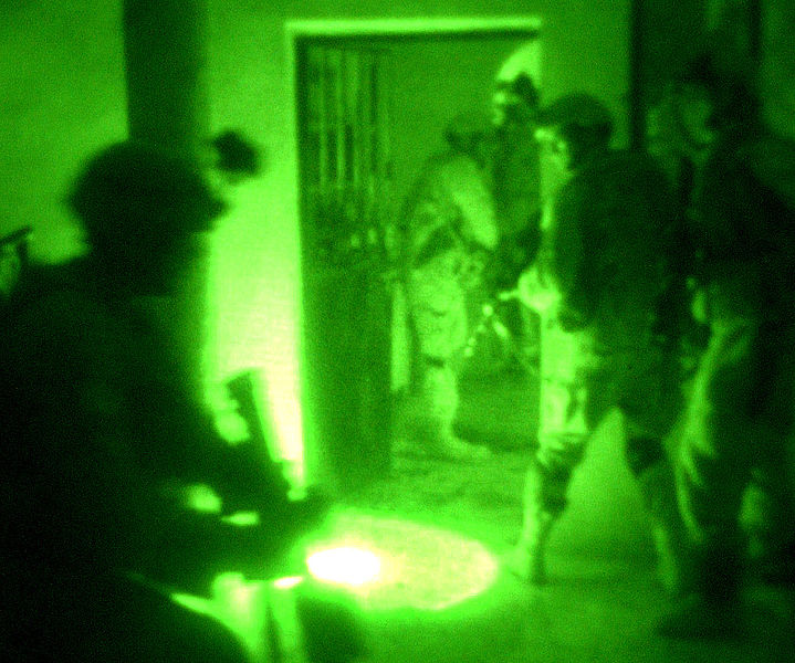 Night-vision bodycam view of multiple figures inside a building.