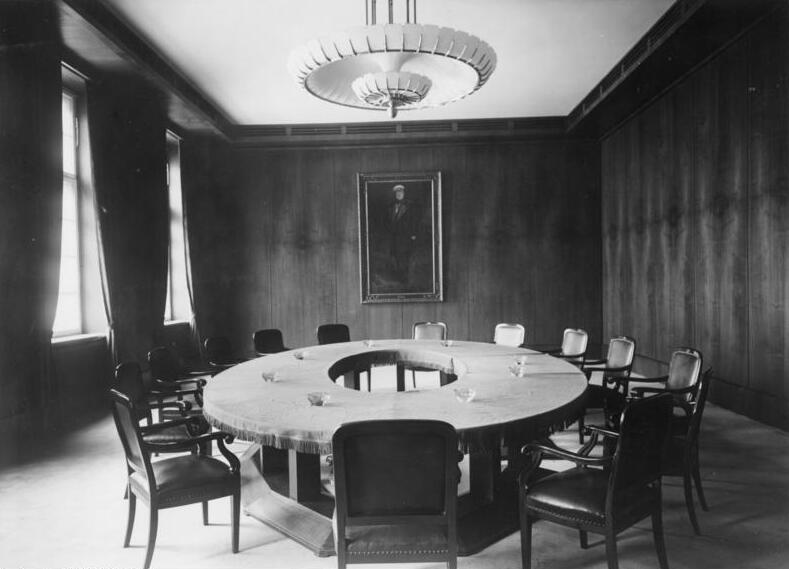 Meeting room decorated by a round table and office chairs.